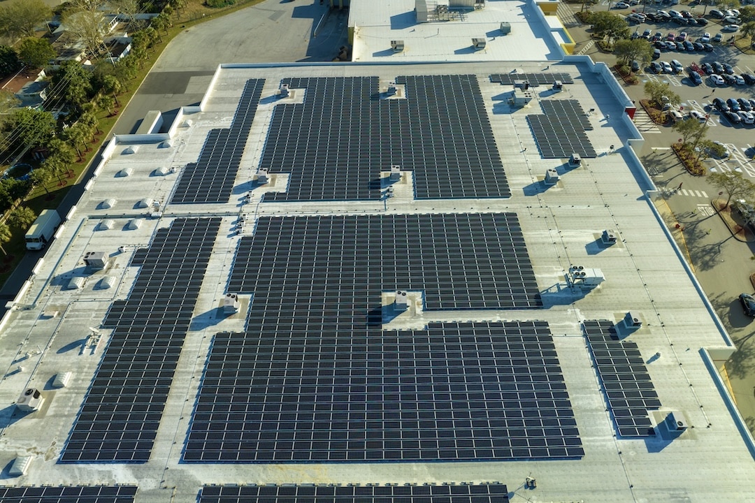 Photovoltaic solar panels mounted on industrial building roof for producing green ecological electricity. Production of sustainable energy concept