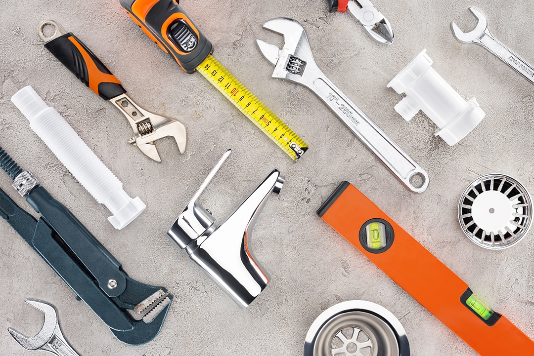 flat lay with various plumbing tools on concrete surface