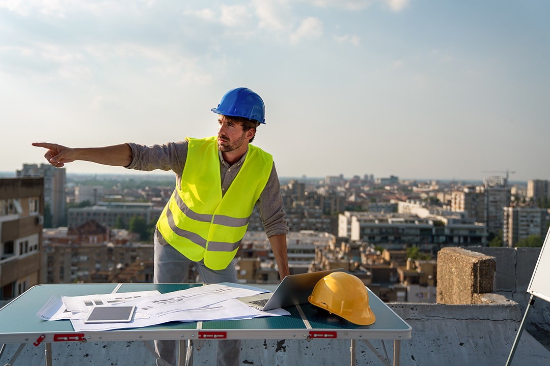 Young businessman construction site engineer working with architect blueprints on construction site. Guide to Managing Construction Projects