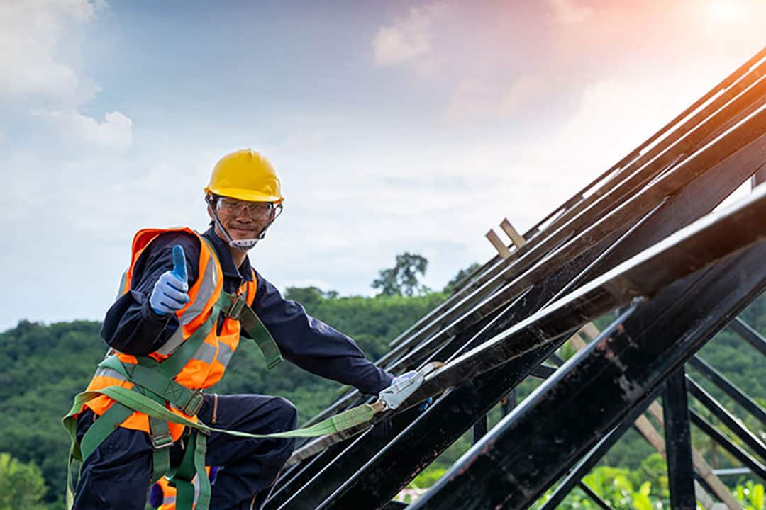 Professional and qualified roofer in protective uniform wear ins. Guide to Managing Construction Projects